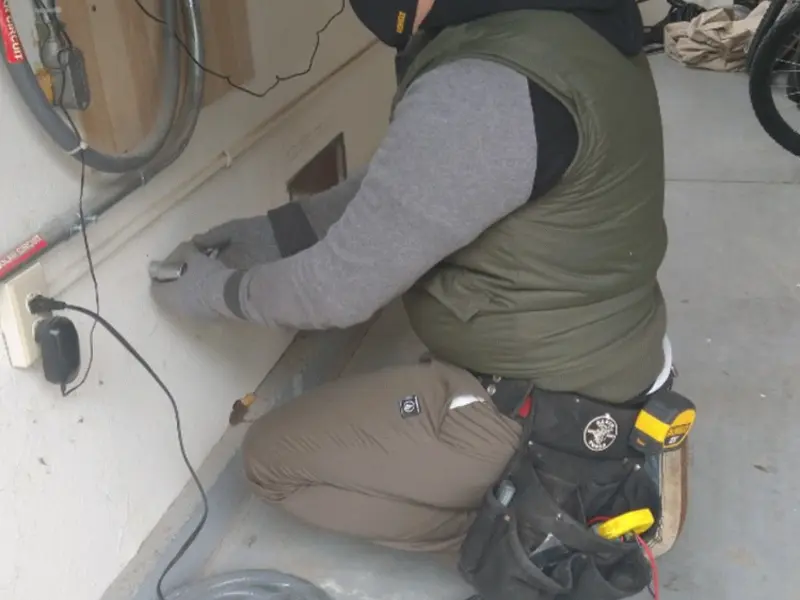 Electrician performing outlet wiring in a Manasquan garage